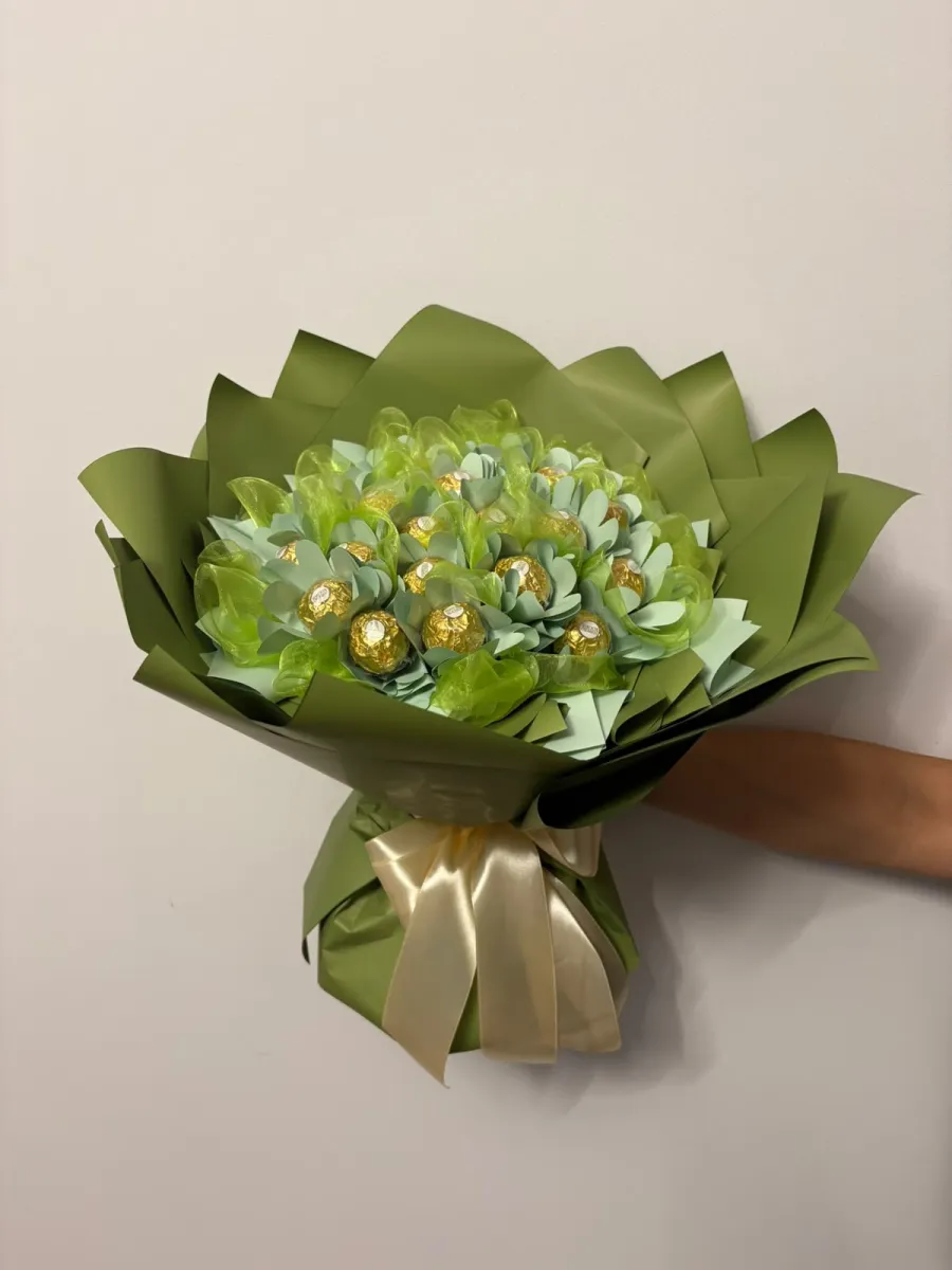 Bukiet w oliwkowej zieleni z pralinkami Ferrero Rocher ułożonymi jak pąki kwiatów i kremową kokardą